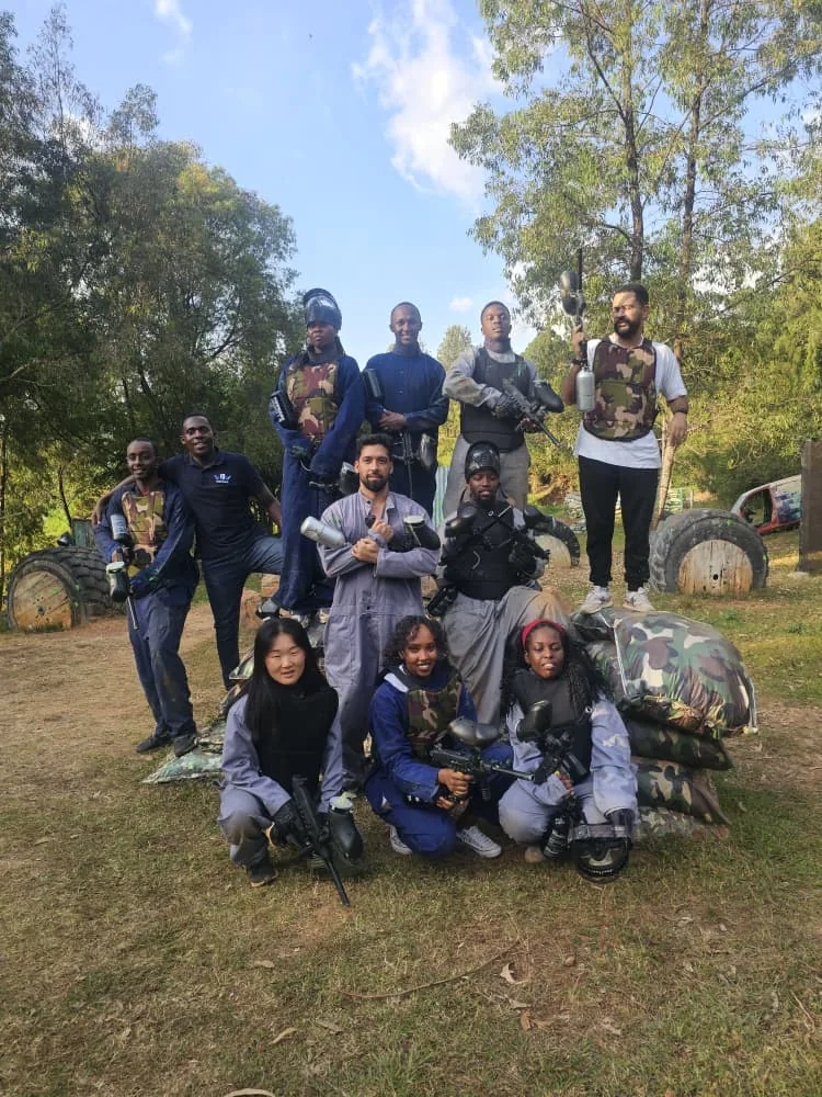 Kigali BJJ teammates gathered outdoors on a rocky hillside