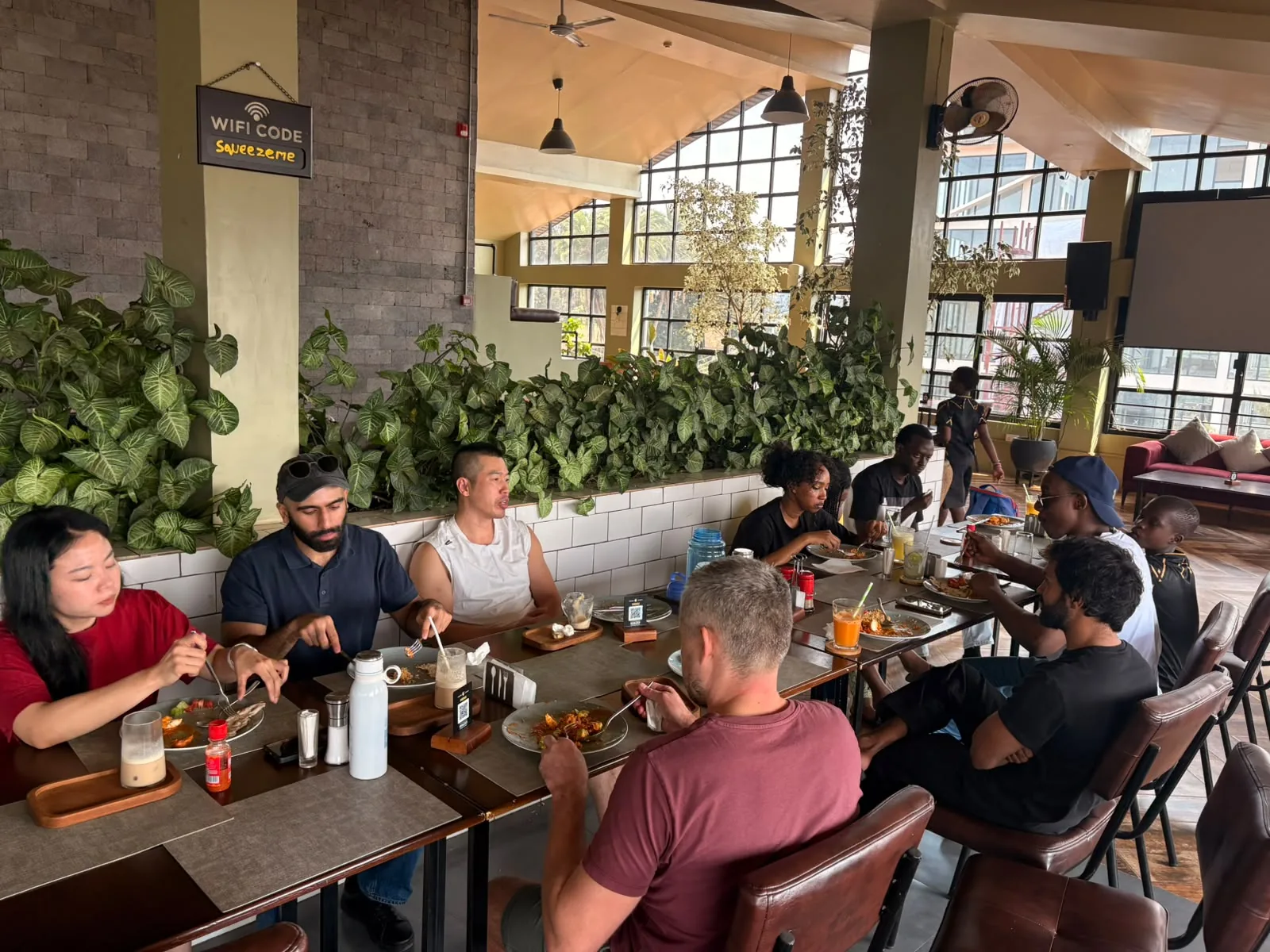 Kigali BJJ teammates sharing a meal around a long table