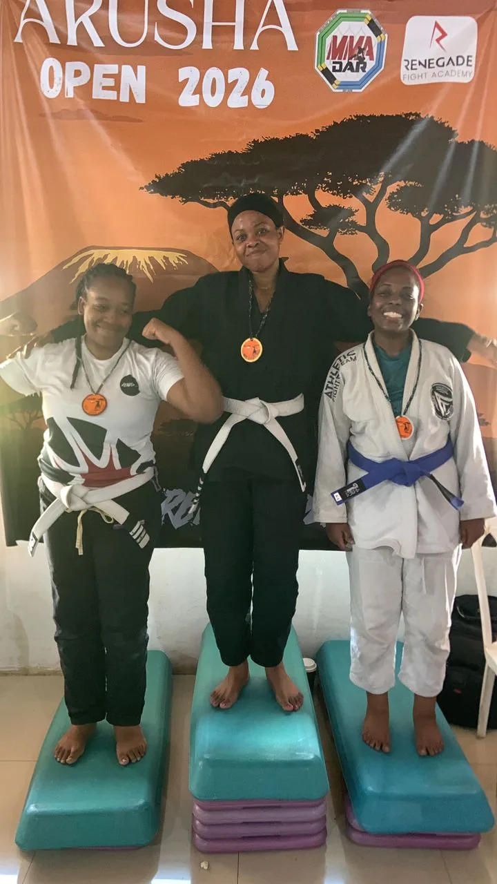 Two Kigali BJJ competitors displaying medals on the podium