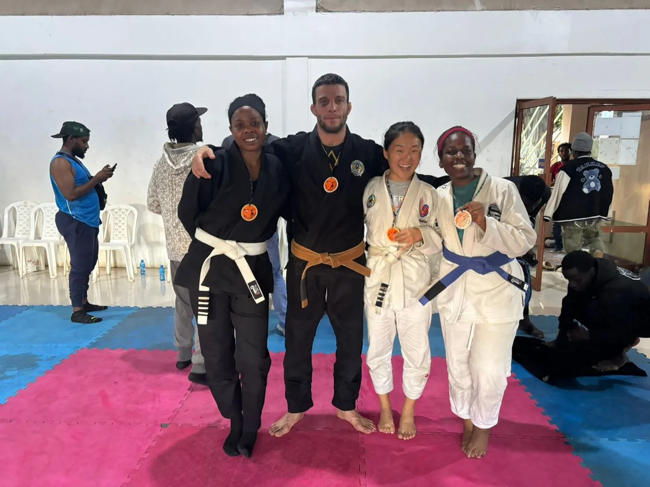 Four Kigali BJJ competitors standing on the mat with medals