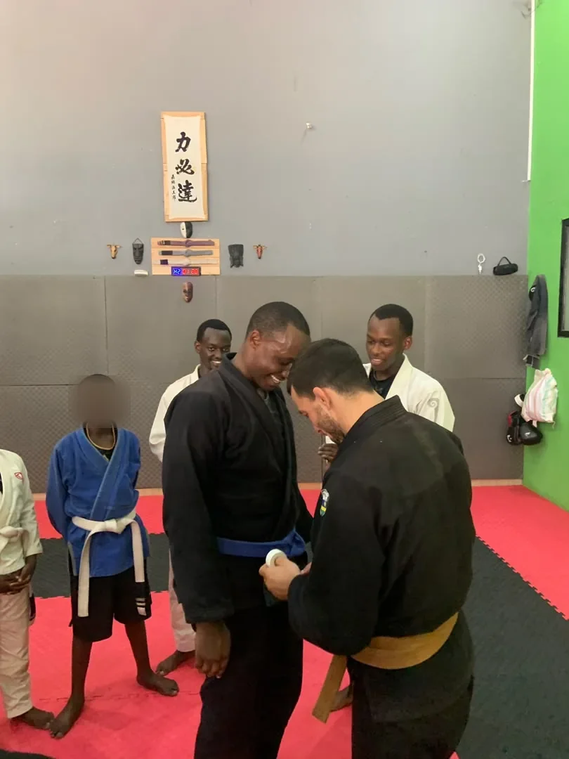 Kigali BJJ coach presenting a belt during a promotion ceremony