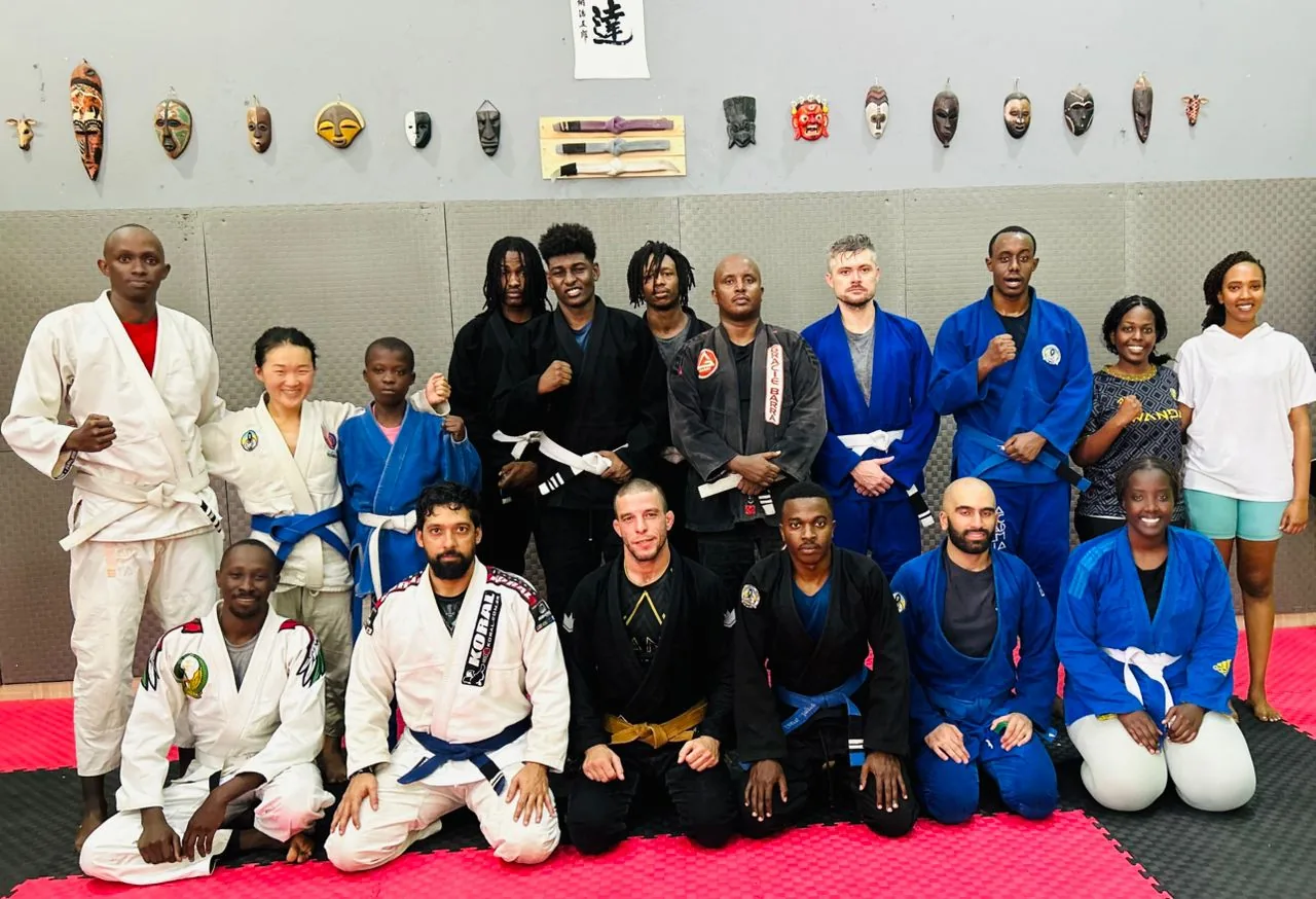A mixed Kigali BJJ class posing in gis and no-gi kit